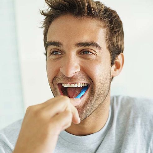 Junger Mann putzt seine Zähne